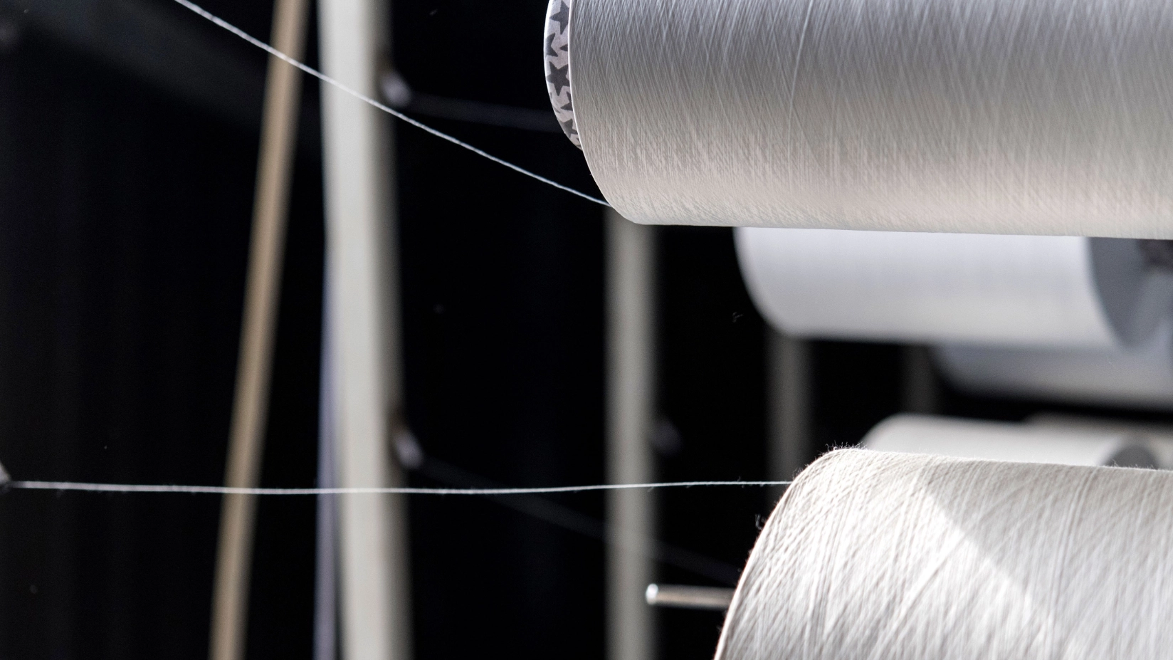 Zwei große weiße Garnrollen sind im Fokus 