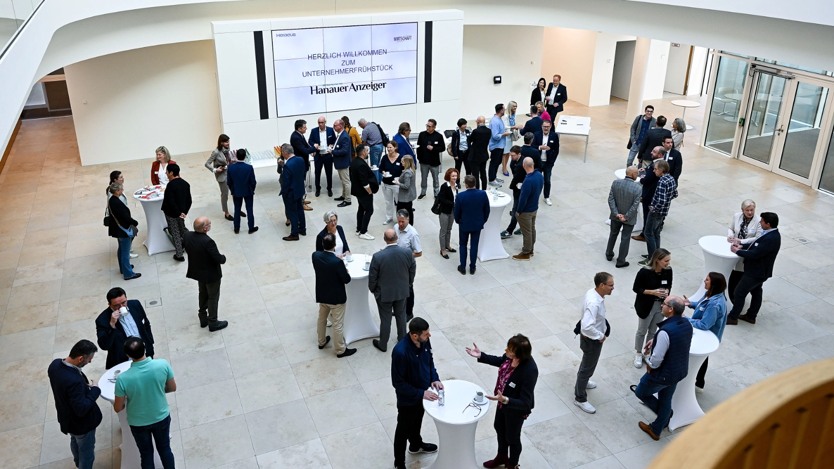 Eine Gruppe von Menschen im Foyer in einem geschäftlichen Kontext.