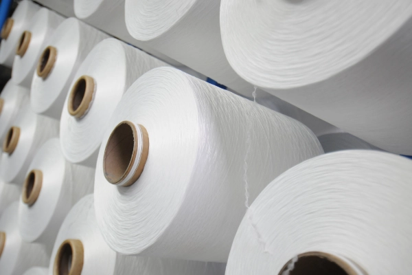 Multiple white yarn rolls laying on one another 