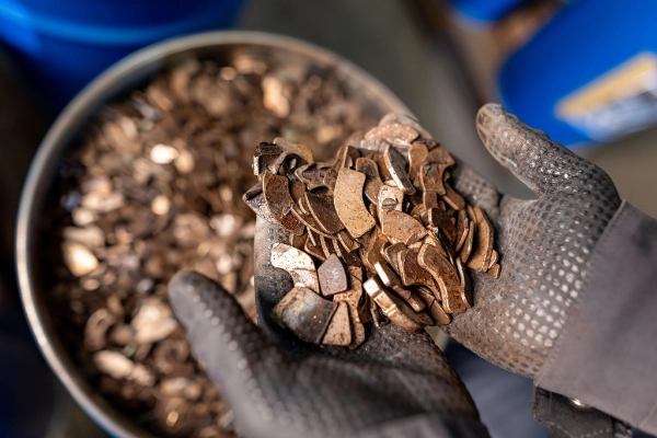 Ein Heraeus Mitarbeiter prüft Seltene-Erden-Altmagnete, die in Computer-Festplatten verbaut waren.