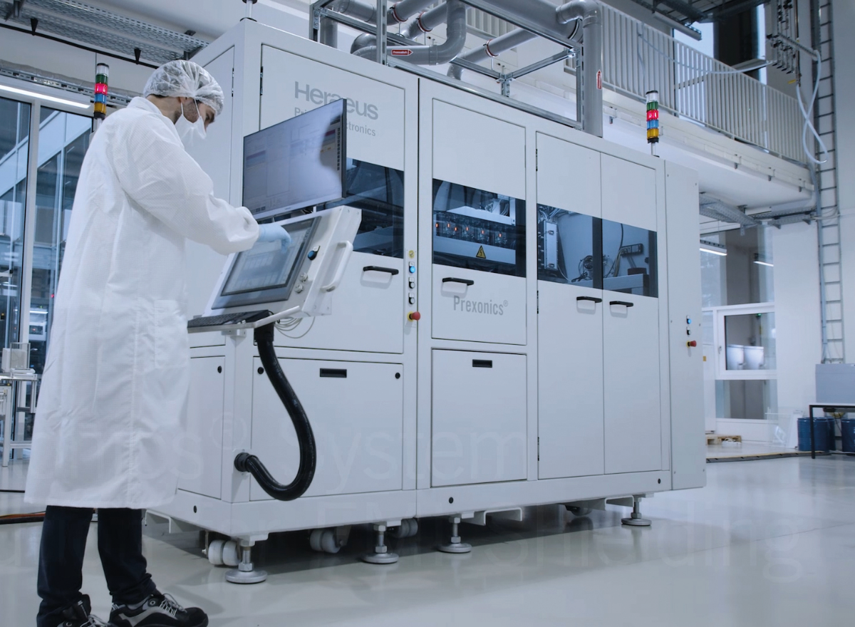 Arbeiter in einem weißen Kittel arbeitet am Terminal des Industrial Inkjet Projector