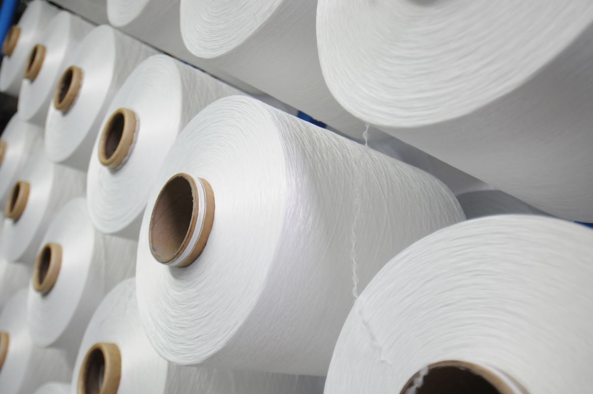 Mehrere übereinander liegende weiße Garnrollen