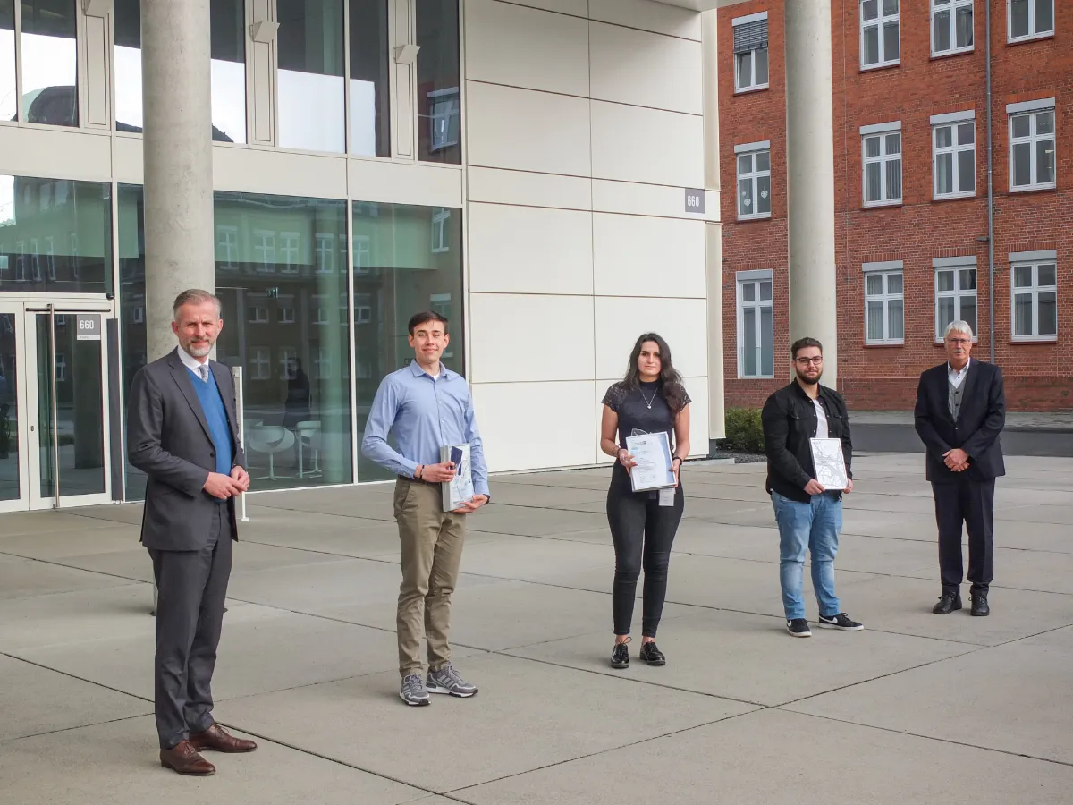 Jan Rinnert mit den drei Absolventen 